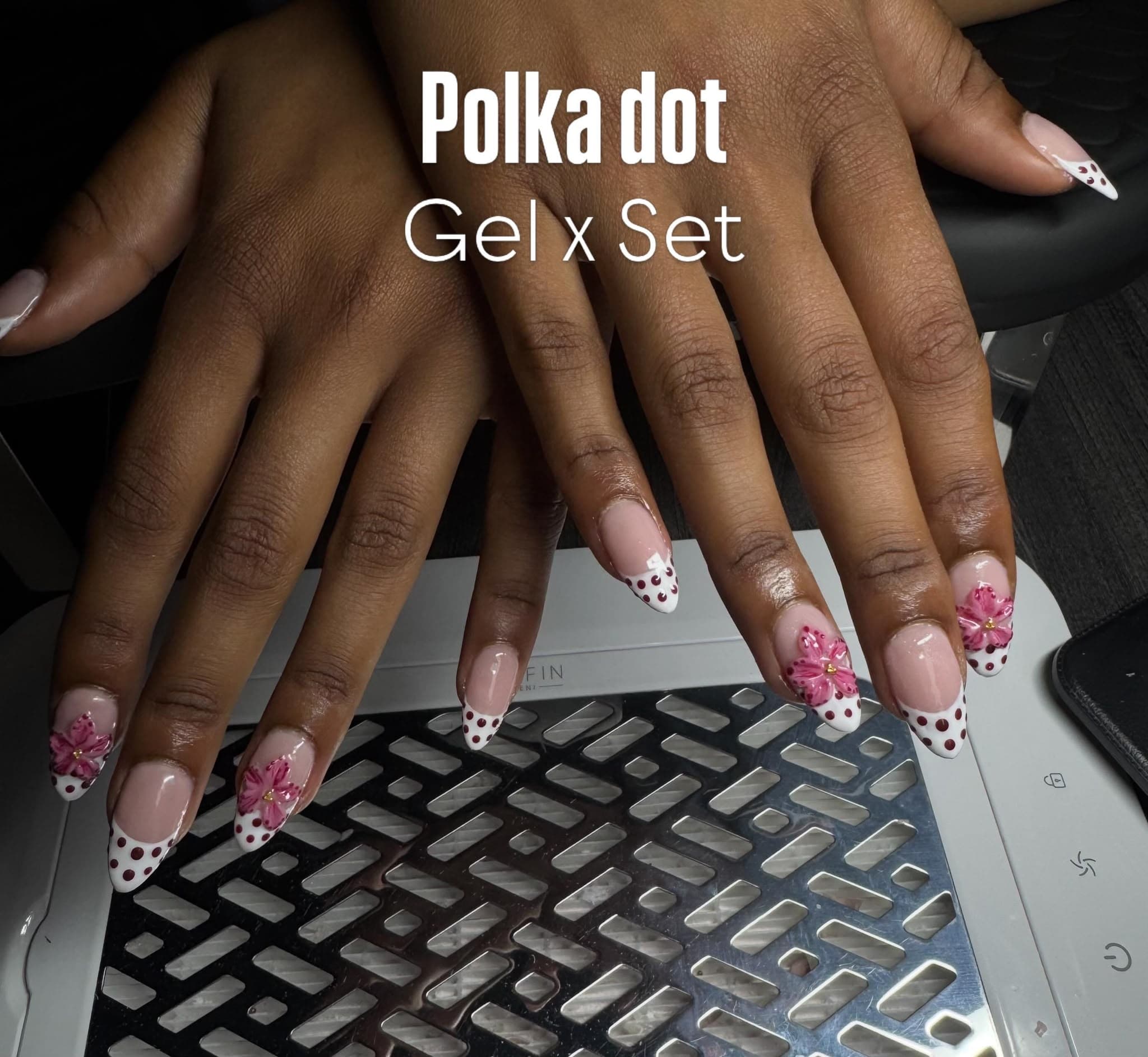 French-Nägel mit weißen Spitzen, dunklen Polka Dots und pinker 3D-Blüte
