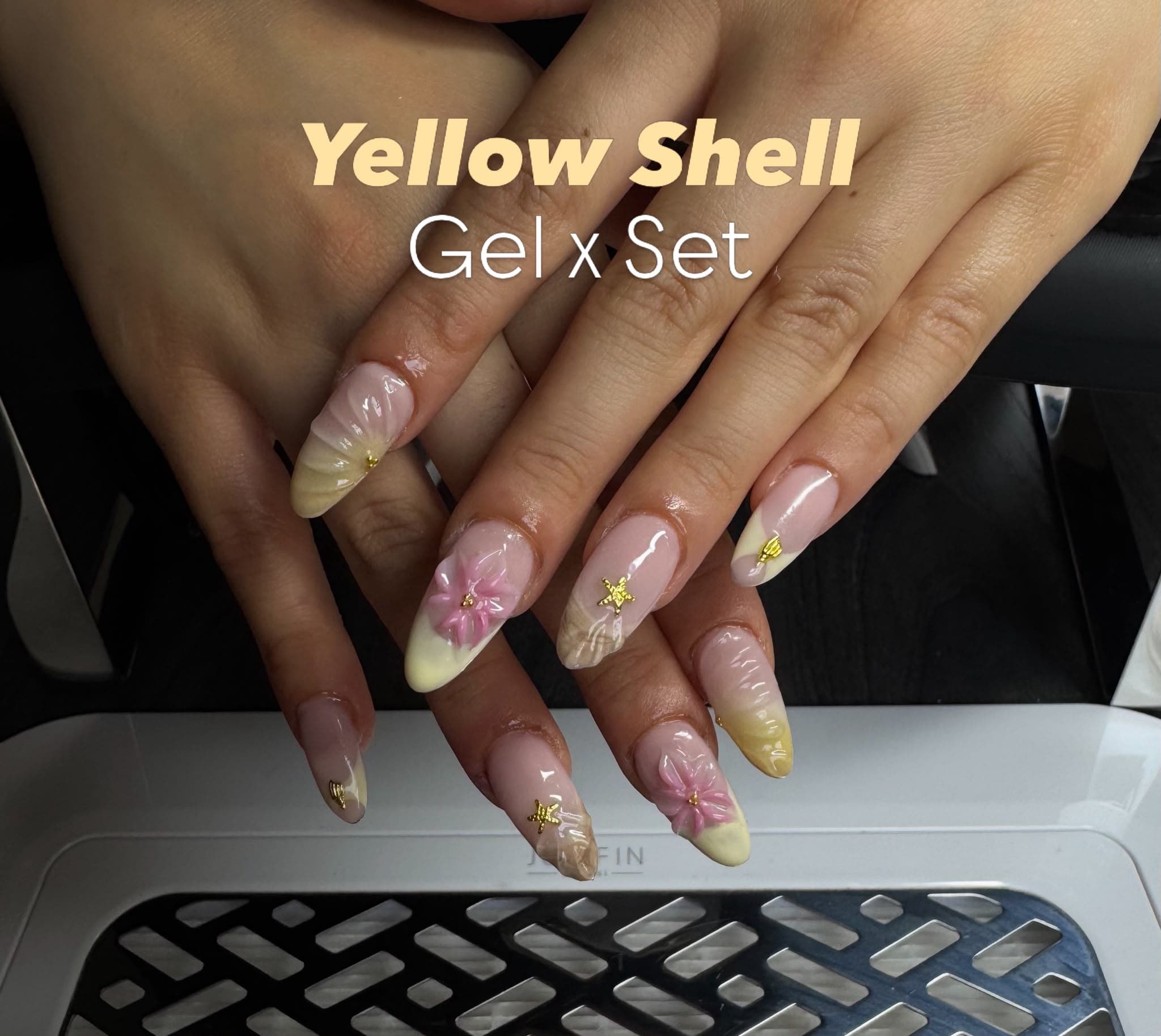 Gel-X Nägel mit gelbem Shell-Design, rosa 3D-Blüten und Gold-Sternen